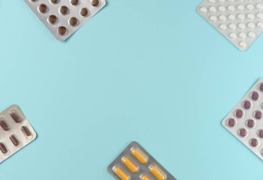 Mavi arka planda farklı haplar bulunan kabarcıkların çerçevesi. Düz yerde, üst tarafta. Boşluğu kopyala