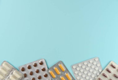 Mavi arka planda farklı haplarla su toplamış. Düz yerde, üst tarafta. Boşluğu kopyala