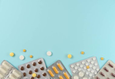 Mavi arka planda farklı haplarla su toplamış. Düz yerde, üst tarafta. Boşluğu kopyala