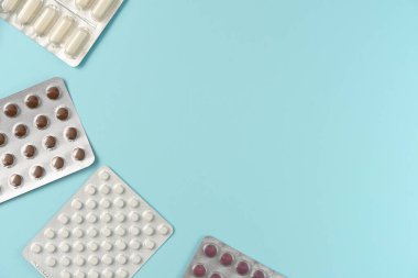 Mavi arka planda farklı haplarla su toplamış. Düz yerde, üst tarafta. Boşluğu kopyala