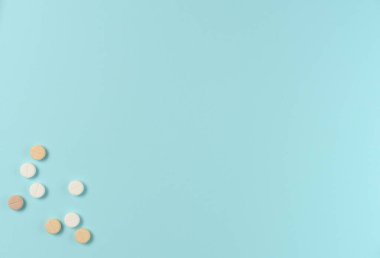 Mavi arka planda bir sürü farklı hap var. Düz yerde, üst tarafta. Boşluğu kopyala