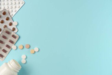 Mavi arka planda farklı haplarla su toplamış. Düz yerde, üst tarafta. Boşluğu kopyala