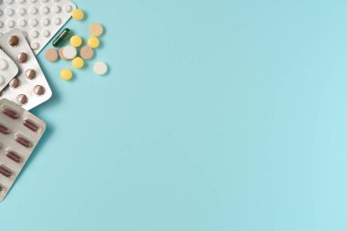 Mavi arka planda farklı haplarla su toplamış. Düz yerde, üst tarafta. Boşluğu kopyala