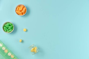 Kavanozlardaki tabletler ve mavi arka plandaki ilaç kutusu. Düz yerde, üst tarafta. Boşluğu kopyala