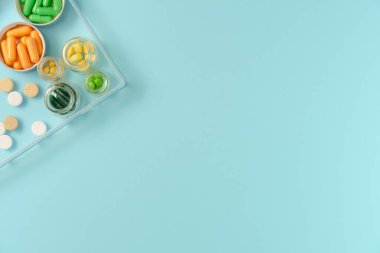 Mavi arka planda ilaç kutusunda haplar. Düz yerde, üst tarafta. Boşluğu kopyala