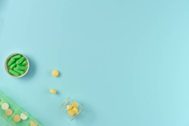 Kavanozlardaki tabletler ve mavi arka plandaki ilaç kutusu. Düz yerde, üst tarafta. Boşluğu kopyala