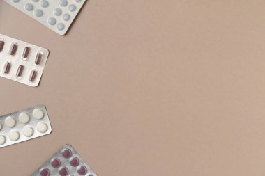 Bej arka planda farklı haplarla su toplamış. Düz yerde, üst tarafta. Boşluğu kopyala