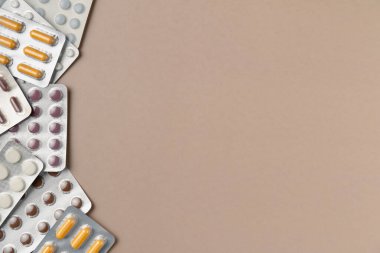 Bej arka planda farklı haplarla su toplamış. Düz yerde, üst tarafta. Boşluğu kopyala