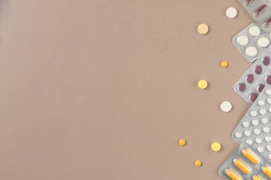 Bej arka planda farklı haplarla su toplamış. Düz yerde, üst tarafta. Boşluğu kopyala