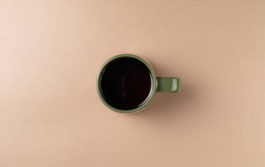 Bej arka planda bir fincan çay. Düz yatış, üst görünüm.