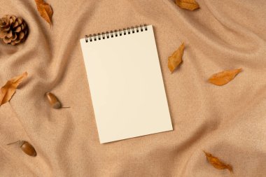 Yukarıdan gelen kumaş arkaplan üzerine boş bir defter. Düz yatış, üst görünüm.