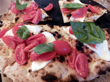 Domates, peynir ve fesleğenli pizza.