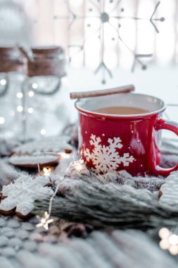 Marşmelovlu sıcak kakao ve tarçınlı fincan beyaz arka planda noel ağacı dallarıyla birlikte..