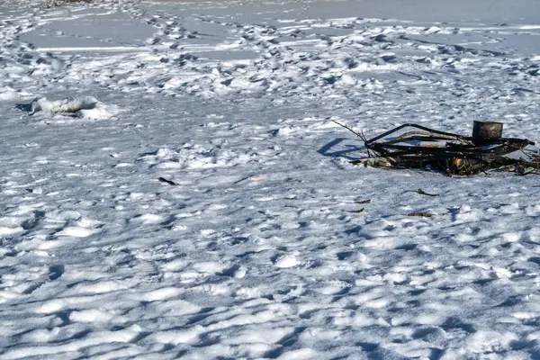 Garbage left by ice fishermen on a frozen lake in Skaraborg Sweden in the hope that the garbage will disappear into the lake when the ice on the lake thaws.