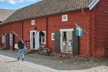 Güneşli bir yaz gününde İsveç 'in Skaraborg kentindeki Vaettern Gölü' ndeki ahşap kasaba Hjo 'dan izler.
