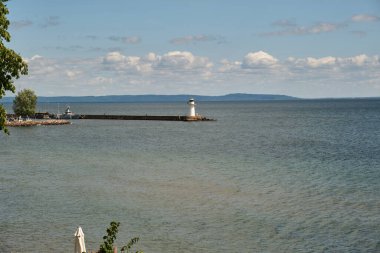 Güneşli bir yaz gününde İsveç 'in Skaraborg kentindeki Vaettern Gölü' ndeki ahşap kasaba Hjo 'dan izler.