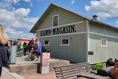 Güneşli bir yaz gününde İsveç 'in Skaraborg kentindeki Vaettern Gölü' ndeki ahşap kasaba Hjo 'dan izler.