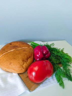 Masada kırmızı domates, biber ve dereotlu taze ekmek.