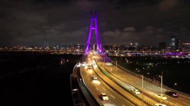 Xinbei Köprüsü 'nün gece görüntüsü. Arabalar renkli ışıklarla köprüden geçer. Yeni Taipei Şehri, Xindian Güneş Işığı Spor Parkı Günışığı Köprüsü.