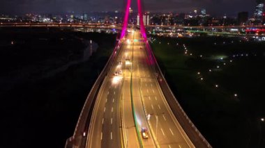 Xinbei Köprüsü 'nün gece görüntüsü. Arabalar renkli ışıklarla köprüden geçer. Yeni Taipei Şehri, Xindian Güneş Işığı Spor Parkı Günışığı Köprüsü.