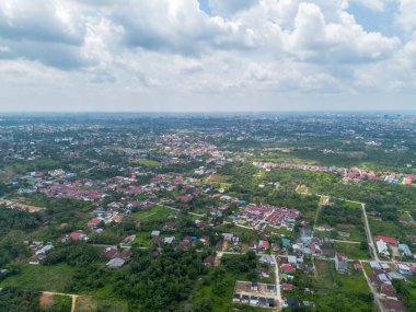 Pekanbaru şehrinin hava manzarası Endonezya 'da birçok ağaçla birlikte gökyüzünde. Birçok konut binası bulunan Riau ilinin başkenti..