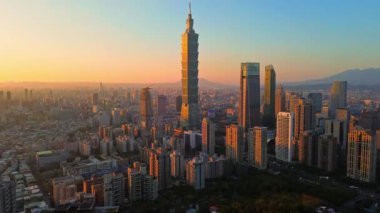 Tayvan 'daki Taipei City Skyline' ın 4K hava görüntüleri. Günbatımında Taipei 101 ile Tayvan 'ın başkentidir. Taipei şehrinin en hızlı büyüyen finansal bölgesinin insansız hava aracı görüntüsü.