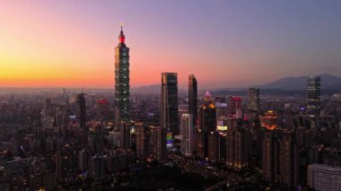 Tayvan 'daki Taipei City Skyline' ın 4K hava görüntüleri. Günbatımında Taipei 101 ile Tayvan 'ın başkentidir. Taipei şehrinin en hızlı büyüyen finansal bölgesinin insansız hava aracı görüntüsü.