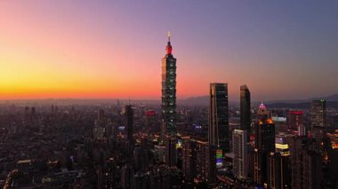 Tayvan 'daki Taipei City Skyline' ın 4K hava görüntüleri. Günbatımında Taipei 101 ile Tayvan 'ın başkentidir. Taipei şehrinin en hızlı büyüyen finansal bölgesinin insansız hava aracı görüntüsü.