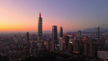 Tayvan 'daki Taipei City Skyline' ın 4K hava görüntüleri. Günbatımında Taipei 101 ile Tayvan 'ın başkentidir. Taipei şehrinin en hızlı büyüyen finansal bölgesinin insansız hava aracı görüntüsü.