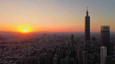 Tayvan 'daki Taipei City Skyline' ın 4K hava görüntüleri. Günbatımında Taipei 101 ile Tayvan 'ın başkentidir. Taipei şehrinin en hızlı büyüyen finansal bölgesinin insansız hava aracı görüntüsü.