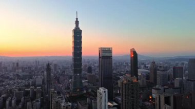 Tayvan 'daki Taipei City Skyline' ın 4K hava görüntüleri. Günbatımında Taipei 101 ile Tayvan 'ın başkentidir. Taipei şehrinin en hızlı büyüyen finansal bölgesinin insansız hava aracı görüntüsü.