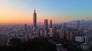 Tayvan 'daki Taipei City Skyline' ın 4K hava görüntüleri. Günbatımında Taipei 101 ile Tayvan 'ın başkentidir. Taipei şehrinin en hızlı büyüyen finansal bölgesinin insansız hava aracı görüntüsü.
