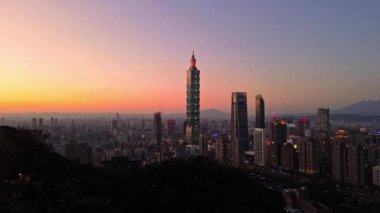 Tayvan 'daki Taipei City Skyline' ın 4K hava görüntüleri. Günbatımında Taipei 101 ile Tayvan 'ın başkentidir. Taipei şehrinin en hızlı büyüyen finansal bölgesinin insansız hava aracı görüntüsü.