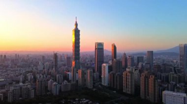 Tayvan 'daki Taipei City Skyline' ın 4K hava görüntüleri. Günbatımında Taipei 101 ile Tayvan 'ın başkentidir. Taipei şehrinin en hızlı büyüyen finansal bölgesinin insansız hava aracı görüntüsü.