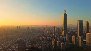 Tayvan 'daki Taipei City Skyline' ın 4K hava görüntüleri. Günbatımında Taipei 101 ile Tayvan 'ın başkentidir. Taipei şehrinin en hızlı büyüyen finansal bölgesinin insansız hava aracı görüntüsü.