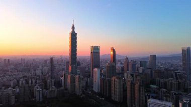 Tayvan 'daki Taipei City Skyline' ın 4K hava görüntüleri. Günbatımında Taipei 101 ile Tayvan 'ın başkentidir. Taipei şehrinin en hızlı büyüyen finansal bölgesinin insansız hava aracı görüntüsü.
