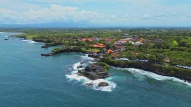 Endonezya, Bali 'deki Tanah Lot' un 4K hava görüntüleri. Küçük bir kayalık adada bulunan geleneksel ve dini bir Bali tapınağıdır ve turistlere onu görme şansı sunar..