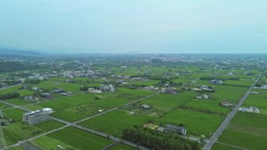 Tayvan, Yilan 'daki havadan 4K pirinç tarlaları. Açık mavi gökyüzü ile güzel bir manzara..