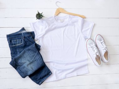White T Shirt mockup weathered, hanger, canvas shoes and Jeans on white wood background shirt templat