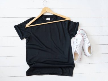 Black T Shirt mockup weathered, hanger, canvas shoes and on white wood background shirt templat