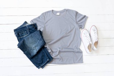 Grey T Shirt mockup weathered, canvas shoes and Jeans on white wood background shirt template