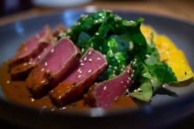 Taze, sulu ton balığı ve güzel gri tabakta ıspanaklı mango salatası..