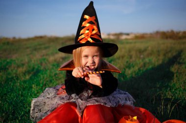 Cadı gibi giyinmiş küçük tatlı kız Cadılar Bayramı 'nı kutluyor..