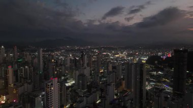 Gece vakti Balnear io Camboriu 'nun engin kentsel yayılımının göz kamaştırıcı bir görüntüsü. Şehir ışıkları karanlık bir gökyüzüne doğru uzanıyor..