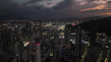 Gece vakti Balnear io Camboriu 'nun engin kentsel yayılışının göz kamaştırıcı bir görüntüsü. Şehir ışıkları karanlık bir gökyüzüne doğru ufka kadar uzanıyor..