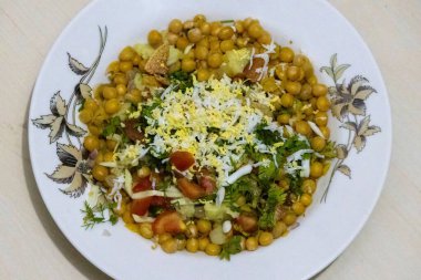 Baharatlı Chotpoti, chaat masala, chana, chola, chili ve yumurta bir tabakta servis edilir. Geleneksel Bangladeş, Hint ve Pakistan yemekleri. Lezzetli Asya sokak yemekleri.