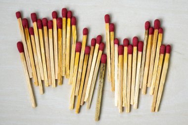 Birçok kibrit çöpü ahşap desenli arka planda. Kibrit çöpleri ateş yakmak, mum yakmak, kağıt yakmak vs. için çok faydalıdır. Kibrit yapımında kullanılan kısa ve ince bir odun parçasıdır..