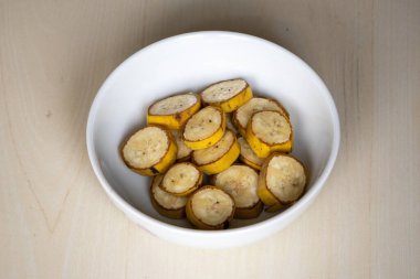 Muz, ahşap arka planda bir kasede dilimler. Muz birçok önemli besin maddeleri içerir ve sindirim, kalp sağlığı ve kilo kaybı için faydalar sağlar. Sağlıklı yeme kavramı.