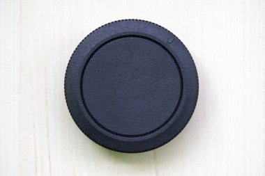 Kamera merceği kapağı ya da beyaz arka planda logo olmayan lens tozu kapağı. Lens kapağı veya lens kapağı kamera lenslerini çizikler, toz, yağmur, kar ve küçük çarpışmalardan korur.