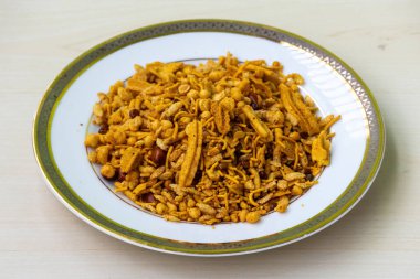 Zengin ve Baharatlı Atıştırmalıklar Bombay Chanachur 'u beyaz tabakta karıştırdı. Bangladeş Çıtır Gıda Bombay ya da Ruchi Klasik Chanachur 'un yakın çekim görüntüsü.